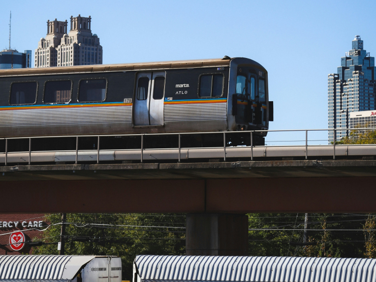 MARTA train on an elevated track with the Downtown Atlanta skyline in the background.