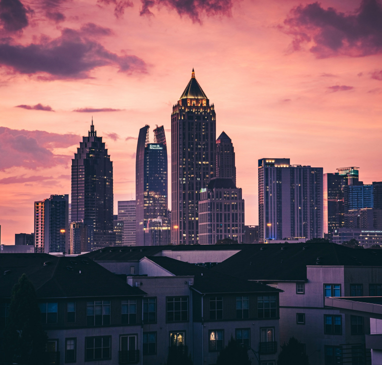 Hotels Near Near Atlanta International Airport (ATL). Atlanta skyline at sunset with downtown and Midtown skyscrapers under a pink sky, Georgia.
