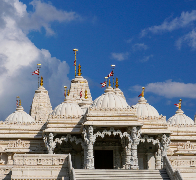 BAPS Shri Swaminarayan Mandir Atlanta in Lilburn, white marble Hindu temple with domes against a blue sky.