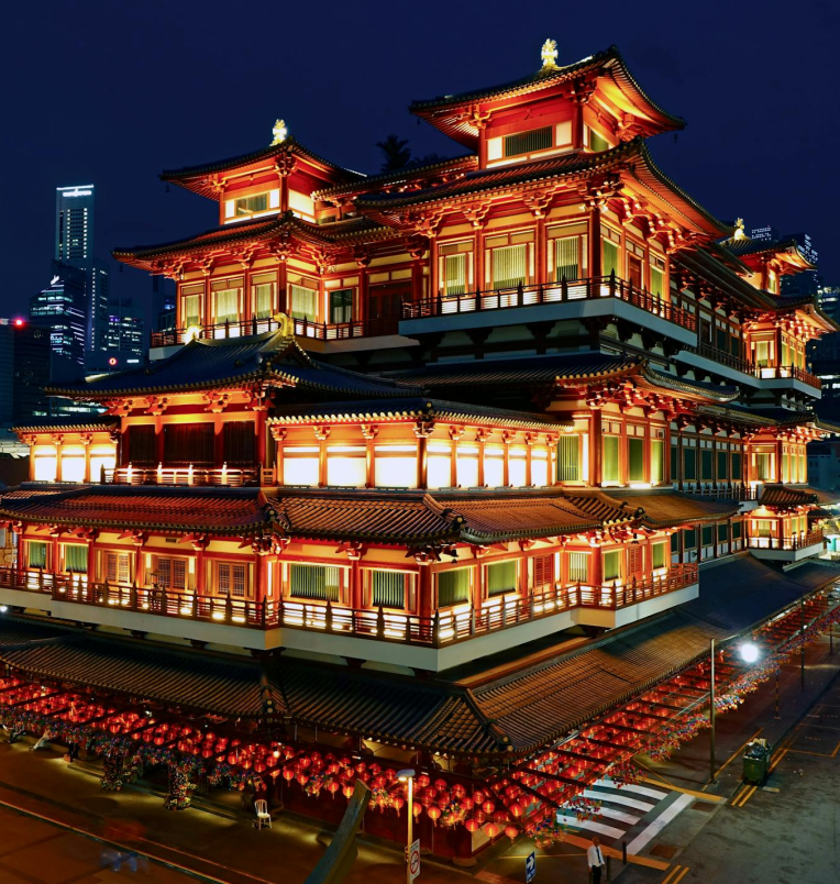 Buddha Tooth Relic Temple illuminated at night in Singapore’s Chinatown, showcasing traditional architecture and vibrant lanterns.