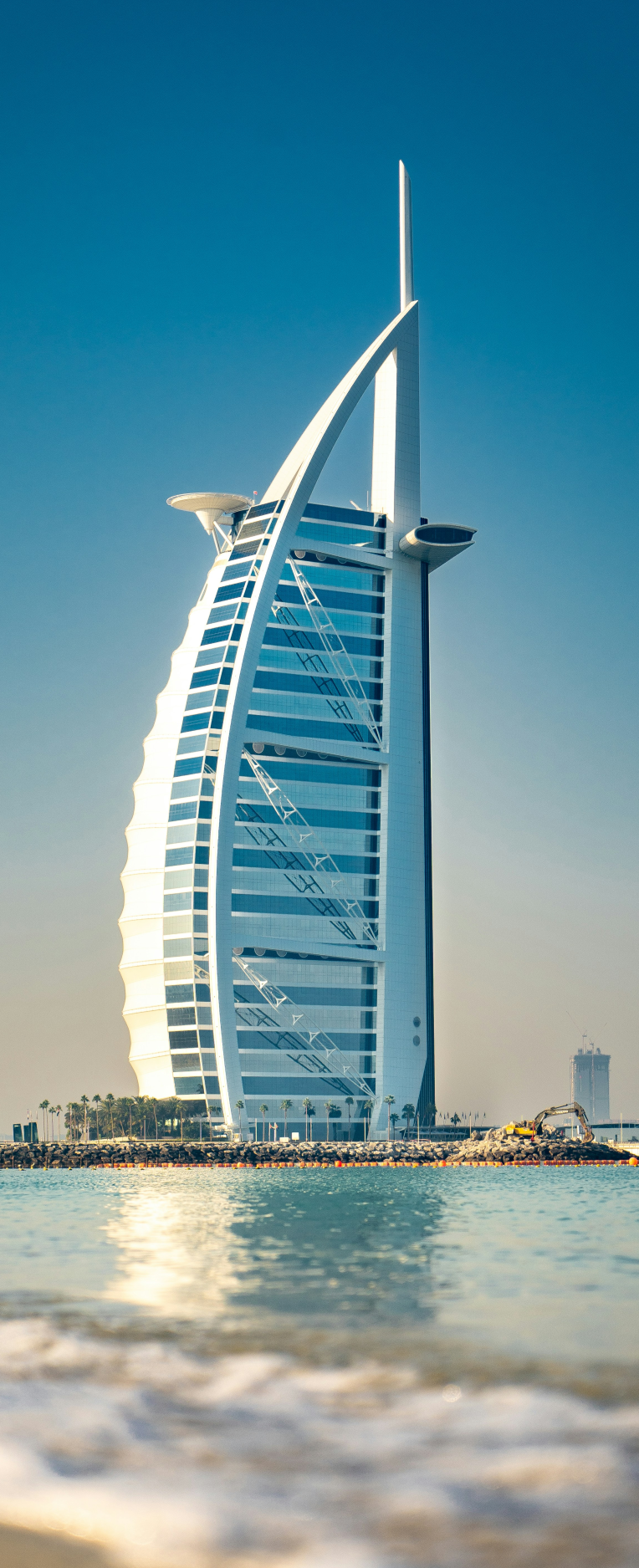 Iconic Burj Al Arab hotel in Dubai viewed from the beach, known for its luxury suites and sail-shaped architecture
