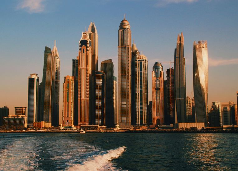 Dubai Marina skyline at sunset with high-rise hotels and apartments along the waterfront promenade