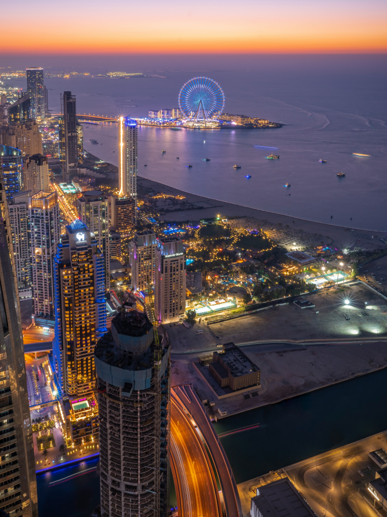Aerial view of Dubai Marina skyline at sunset with Ain Dubai observation wheel and Bluewaters Island in the background