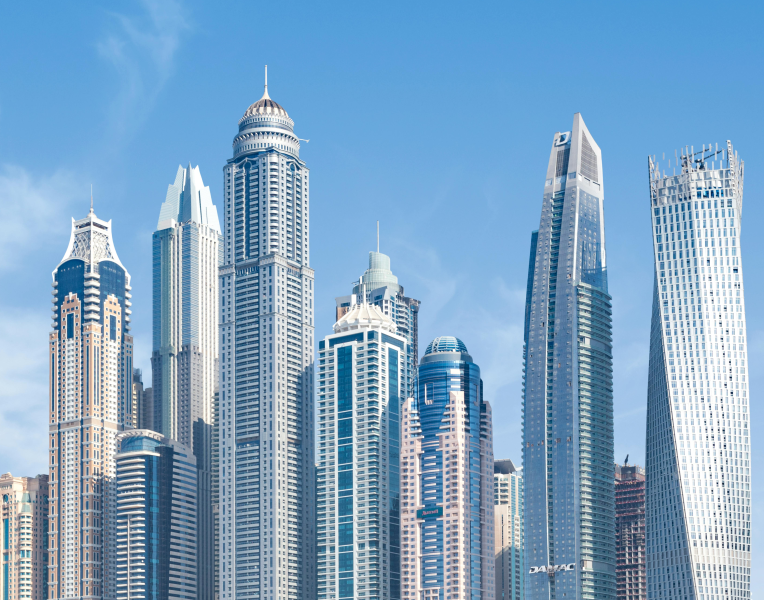 Dubai Marina skyline with modern skyscrapers against a clear blue sky.