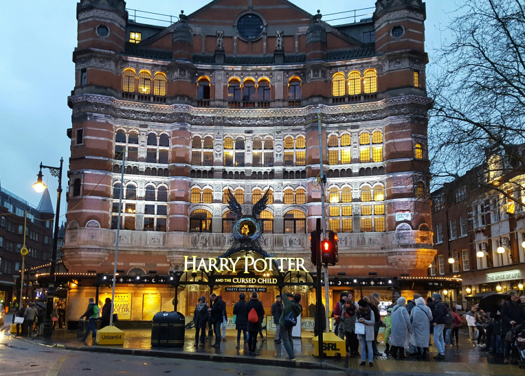 Historic Palace Theatre, London, lit up with ‘Harry Potter and the Cursed Child’ signage and evening street scene.