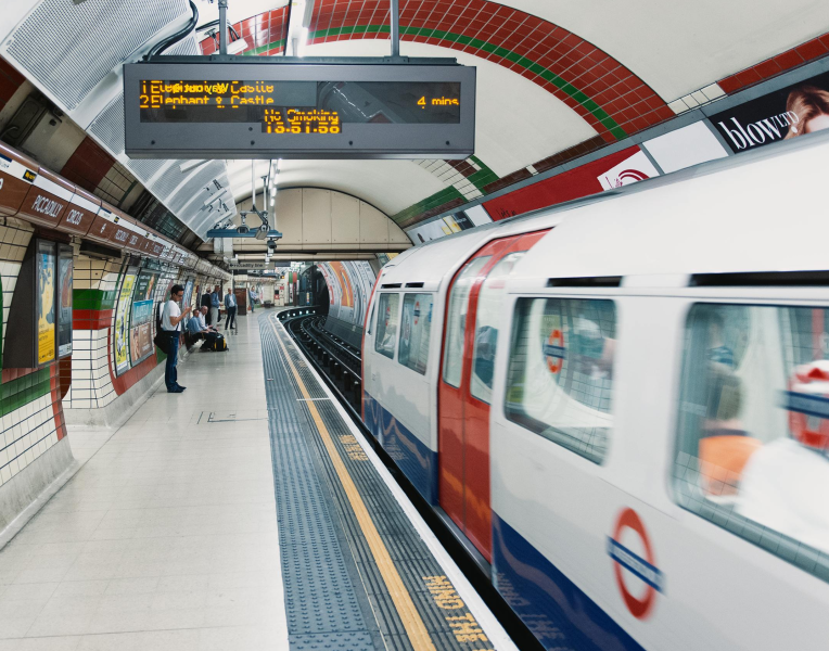 London Underground Tube train arriving at a tiled station platform in Central London.