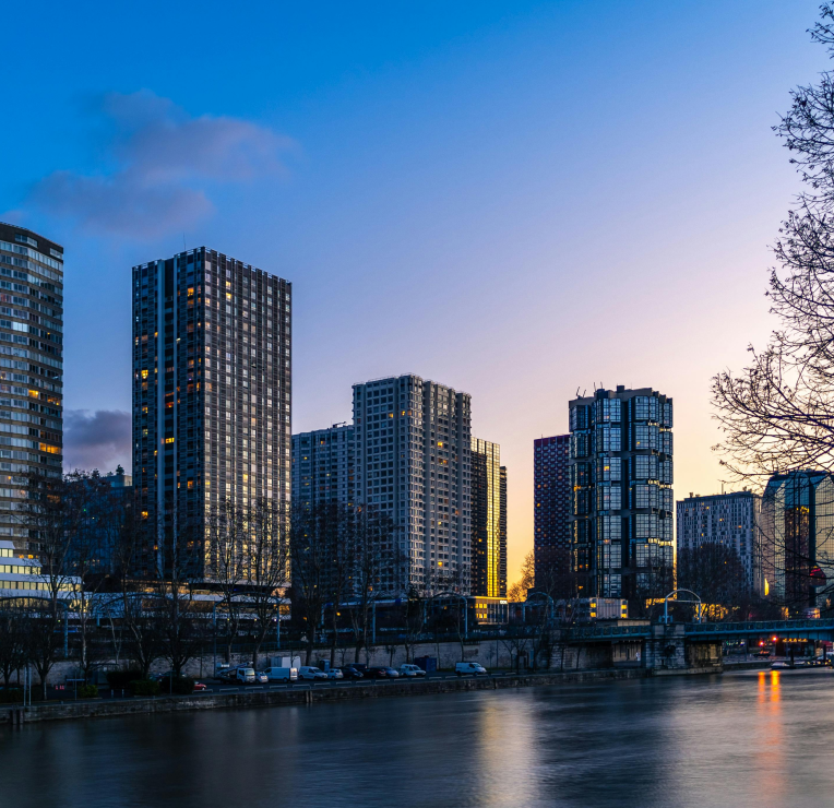 Modern high-rise buildings along the Seine River in Paris at dusk