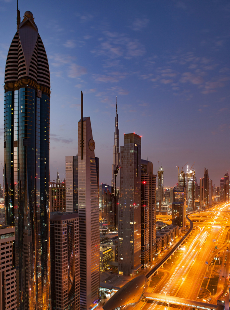 Sheikh Zayed Road skyline at night in Dubai with Burj Khalifa in the background and illuminated highways leading to top hotel districts