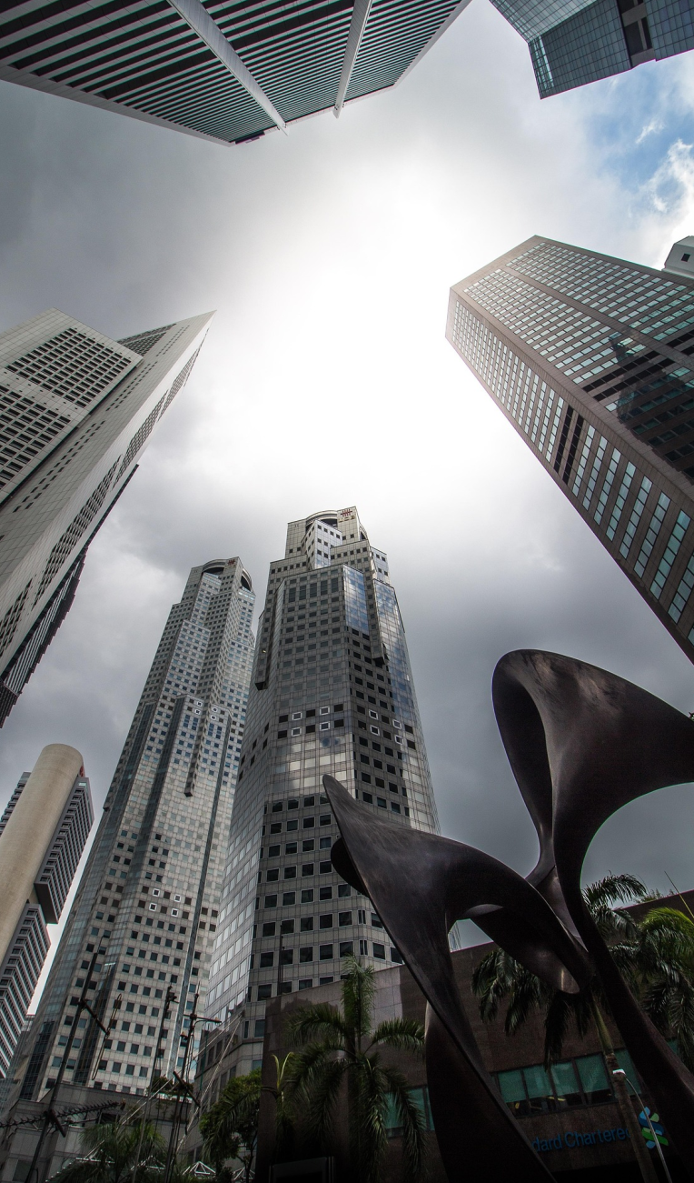 Skyscrapers towering over Singapore’s Central Business District with dramatic sky and modern city architecture.