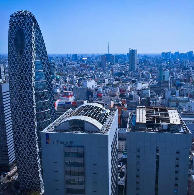 Tokyo skyline viewed from Shinjuku featuring the Mode Gakuen Cocoon Tower and surrounding high-rise buildings.