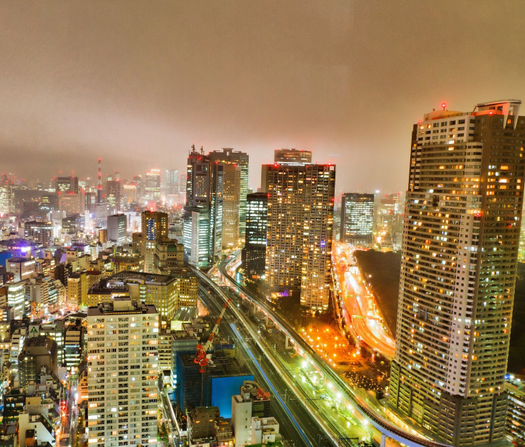Night view of Tokyo city skyline with illuminated highways and high-rise buildings.