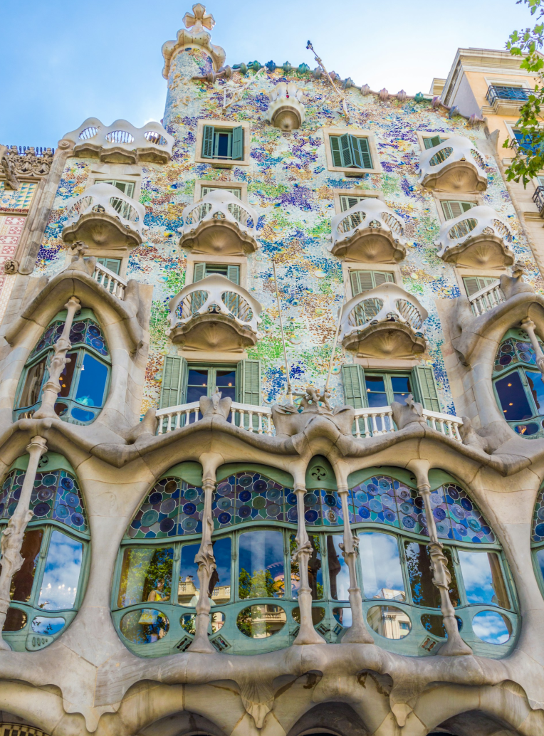 Casa Batlló in Barcelona designed by Antoni Gaudí, featuring colorful mosaic facade, organic balconies, and stained glass windows in the Eixample district.