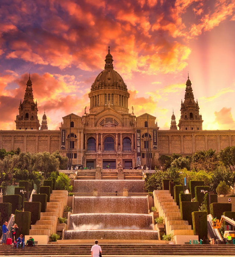 Palau Nacional housing the National Art Museum of Catalonia (MNAC) in Barcelona at sunset, featuring the grand dome, twin towers, and cascading Magic Fountain steps.