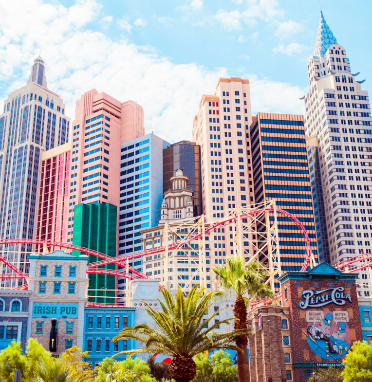 New York-New York Hotel and Casino in Las Vegas featuring replica Manhattan skyline and red roller coaster on the Las Vegas Strip under a sunny sky.