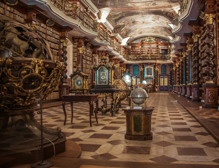 Baroque library hall at the Klementinum in Prague with ornate frescoed ceiling, historic globes and wooden bookshelves, Czech Republic.