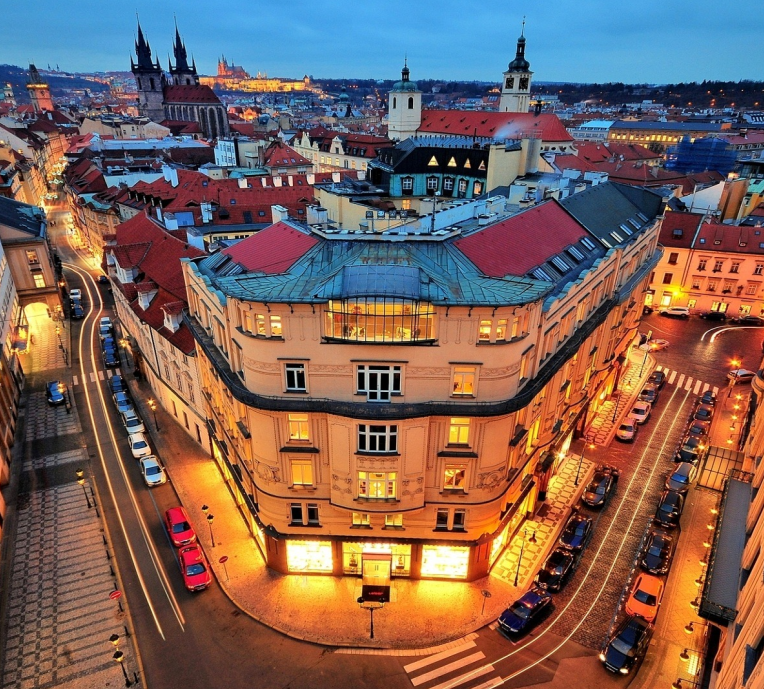 Prague Old Town at night with illuminated streets, historic buildings and red rooftops viewed from above, Czech Republic.