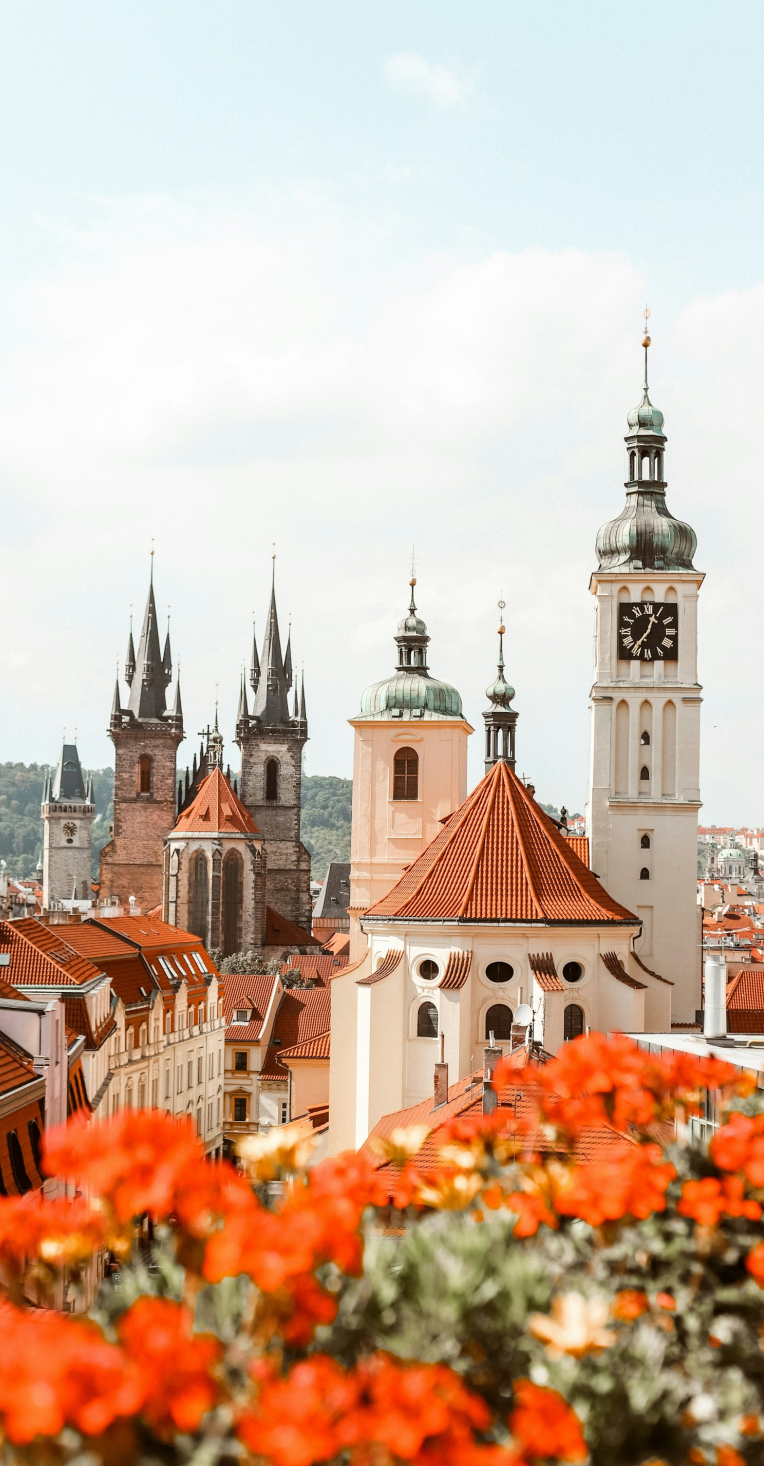 Where to Stay in Prague. Prague Old Town skyline with red rooftops, church towers and clock tower viewed from above, Czech Republic.