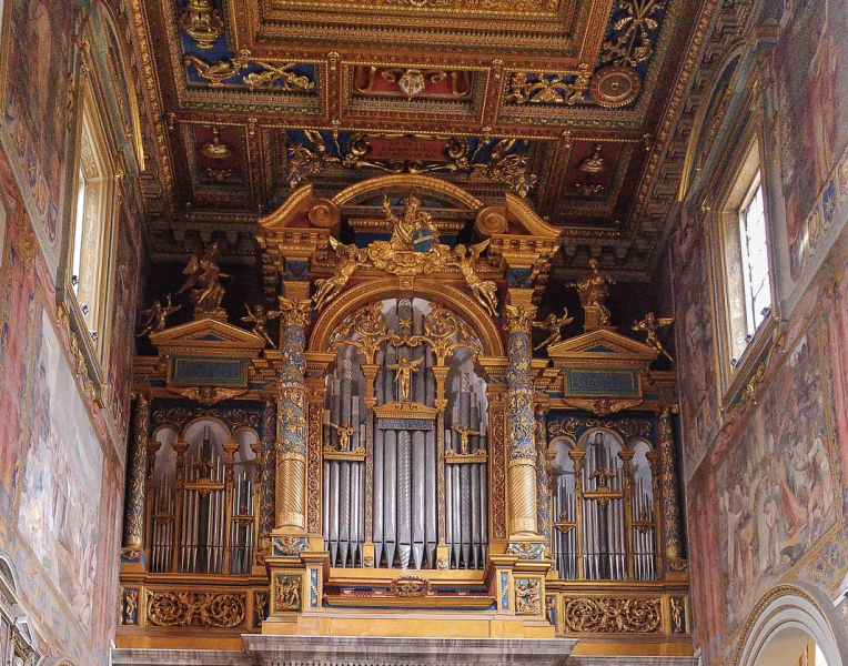 Ornate chapel interior in the Vatican Museums featuring a grand pipe organ, gilded baroque decorations and richly painted ceiling frescoes in Vatican City.