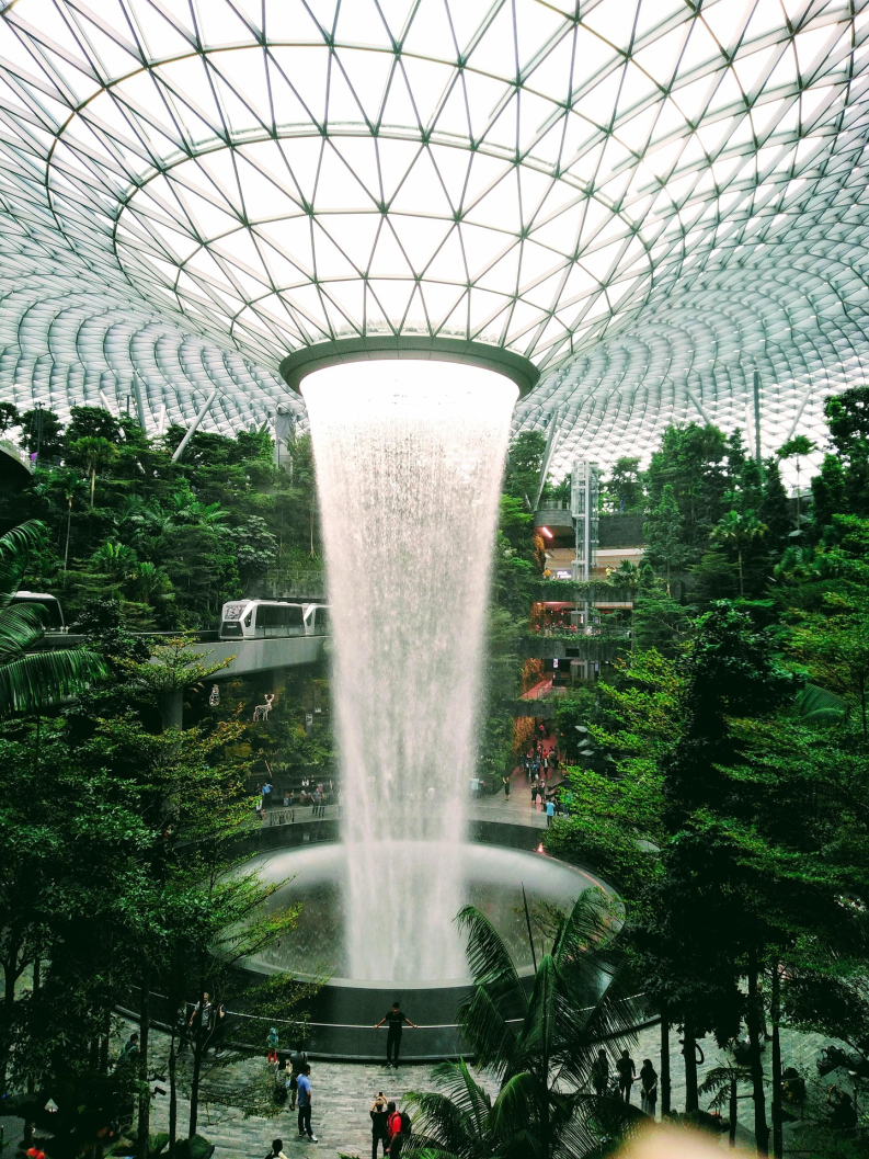 Jewel Changi Airport Rain Vortex waterfall surrounded by indoor forest and glass dome architecture in Singapore.